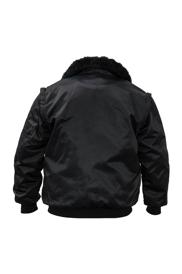 Ein Mann in einer signalgelb-schwarzen Korntex-Pilotenjacke steht vor einem Gebäude