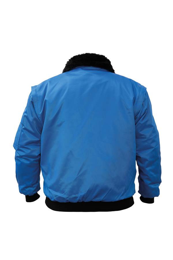 Ein Mann in einer signalgelb-schwarzen Korntex-Pilotenjacke steht vor einem Gebäude